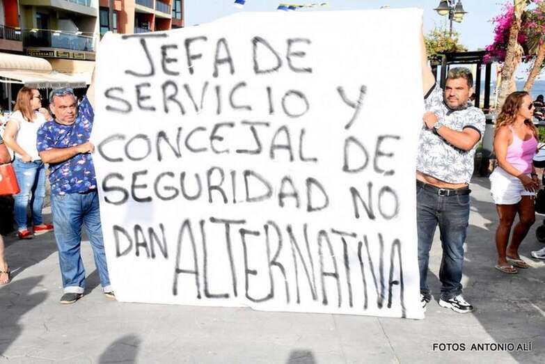 Dos feriantes, ayer en la protesta de Melenara con una pancarta contra la jefa de servicio y concejal de Seguridad (Foto TA)